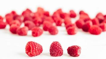 Fresh red raspberries on a white table background photo