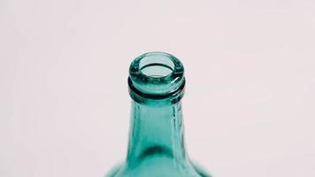 Glass transparent green bottle for liquids without the cap on a white background photo