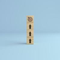 Arrow up with wooden cube blocks tower with target icon on white background. photo