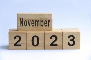 November 2023 text on wooden blocks with white color background. Copy space photo