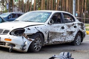 A car destroyed by shrapnel from a rocket that exploded nearby. Irpensky automobile cemetery. Consequences of the invasion of the Russian army in Ukraine. Ukraine, Irpen - May 12, 2022. photo