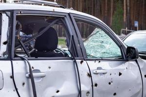 Car riddled with bullets. War of Russia against Ukraine. A car of civilians shot by the Russian military during the evacuation of women and children. Ukraine, Irpen - May 12, 2022. photo