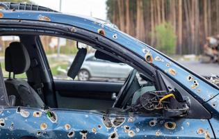 Car riddled with bullets. War of Russia against Ukraine. A car of civilians shot by the Russian military during the evacuation of women and children. Ukraine, Irpen - May 12, 2022. photo