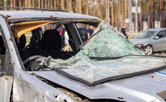 Car riddled with bullets. War of Russia against Ukraine. A car of civilians shot by the Russian military during the evacuation of women and children. Traces of bullets and fragments of shells. photo