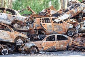 coches quemados oxidados destruidos por explosiones de cohetes. guerra en ucrania. los vehículos destruidos de los civiles que se marchaban fueron evacuados de la zona de combate de bucha e irpin. cementerio de autos foto