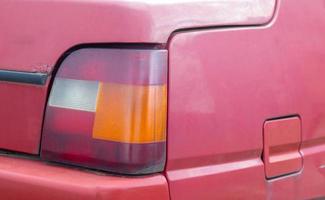 Lantern or reverse signal. The right taillight of a red classic retro car. The size of the Soviet-made machine. Light signal of white, red and orange, indicating the reverse of the car. photo