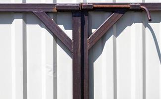 Latch on the gate. Design for locking the gate from the inside. Old rusty padlock on a metal fence. Locking latch on the gate. photo