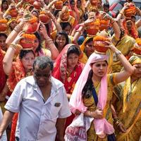 nueva delhi, india 03 de abril de 2022 - mujeres con kalash en la cabeza durante el templo jagannath mangal kalash yatra, devotos hindúes indios llevan ollas de barro que contienen agua sagrada con un coco encima foto