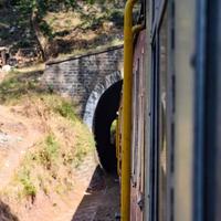 Toy Train moving on mountain slopes, beautiful view, one side mountain, one side valley moving on railway to the hill, among green natural forest. Toy train from Kalka to Shimla in India photo