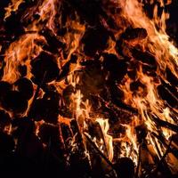 llamas de fuego sobre fondo negro, fondo de textura de llama de fuego blaze, maravillosamente, el fuego está ardiendo, llamas de fuego con madera y hoguera de estiércol de vaca foto