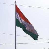 India flag flying high at Connaught Place with pride in blue sky, India flag fluttering, Indian Flag on Independence Day and Republic Day of India, tilt up shot, waving Indian flag, Flying India flags photo