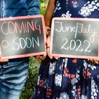 Indian couple posing for maternity baby shoot. The couple is posing in a lawn with green grass and the woman is falunting her baby bump in Lodhi Garden in New Delhi, India photo