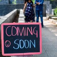 Indian couple posing for maternity baby shoot. The couple is posing in a lawn with green grass and the woman is falunting her baby bump in Lodhi Garden in New Delhi, India photo