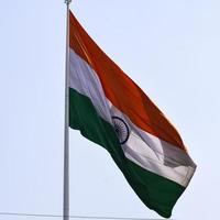 India flag flying high at Connaught Place with pride in blue sky, India flag fluttering, Indian Flag on Independence Day and Republic Day of India, tilt up shot, waving Indian flag, Flying India flags photo