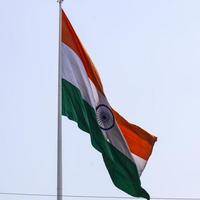 India flag flying high at Connaught Place with pride in blue sky, India flag fluttering, Indian Flag on Independence Day and Republic Day of India, tilt up shot, waving Indian flag, Flying India flags photo