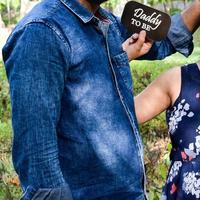 Indian couple posing for maternity baby shoot. The couple is posing in a lawn with green grass and the woman is falunting her baby bump in Lodhi Garden in New Delhi, India photo