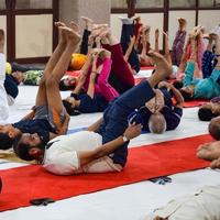 New Delhi, India, June 19 2022 -Group Yoga exercise session for people of different age groups in Balaji Temple, Vivek Vihar, International Yoga Day, Big group of adults attending yoga class in temple photo