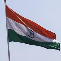 India flag flying high at Connaught Place with pride in blue sky, India flag fluttering, Indian Flag on Independence Day and Republic Day of India, tilt up shot, waving Indian flag, Flying India flags photo