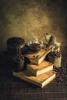 Coffee in cup glass on old books and aged wood floor photo