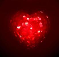 Red Blur heart shape of ligth bokeh on a black background photo