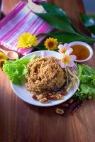 Fluffy spicy catfish with mango sauce Dish dishes on wooden floor Yum Pla-duke Fu photo