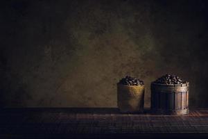 coffee beans in container on wood floor and old paper vintage aged background or texture photo