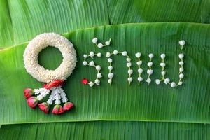 guirnalda tradicional tailandesa de jazmín. símbolo del día de la madre en tailandia en hoja de plátano con amor madre en palabra tailandesa. foto