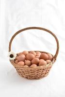 eggs in basket filled isolated on white background photo