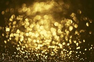 Golden glitter bokeh lighting texture Blurred abstract background for birthday, anniversary, wedding, new year eve or Christmas photo