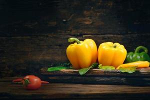 Bell pepper with vegetables on the old wooden floor photo