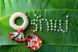 guirnalda tradicional tailandesa de jazmín. símbolo del día de la madre en tailandia en hoja de plátano con amor madre en palabra tailandesa. foto