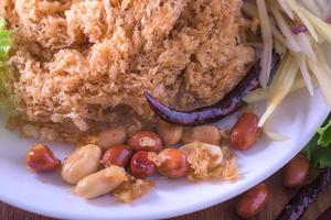 Fluffy spicy catfish with mango sauce Dish dishes on wooden floor Yum Pla-duke Fu photo