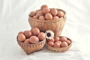 Huevos en cesta llena aislado sobre fondo blanco. foto