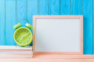 reloj en libro y pizarra blanca con concepto de educación de fondo de piso de madera foto