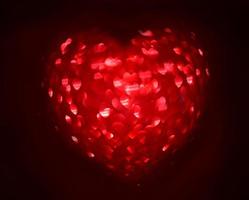 Red Blur heart shape of ligth bokeh on a black background photo