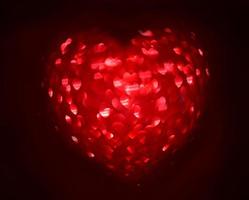 Red Blur heart shape of ligth bokeh on a black background photo