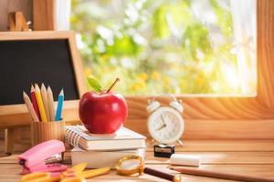 Apple placed on a book with education equipment by the window to morning light, Back to School concept and copy space photo