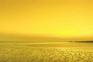 hermosa puesta de sol con coloridas nubes de cielo en el mar foto