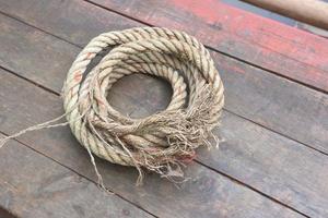 The rope rests on a wooden background photo
