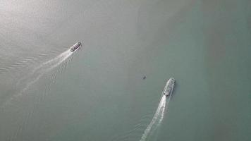 vista aérea ferry y barco navegan en la misma dirección en penang, malasia. video