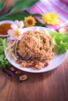 Fluffy spicy catfish with mango sauce Dish dishes on wooden floor Yum Pla-duke Fu photo