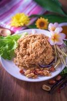 Fluffy spicy catfish with mango sauce Dish dishes on wooden floor Yum Pla-duke Fu photo