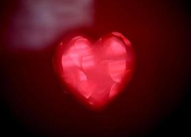 Red Blur heart shape of ligth bokeh on a black background photo