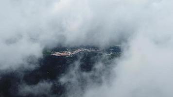 fliegen sie über den nebligen himmel mit grünem dschungel und der kleinen stadt balik pulau im hintergrund. video