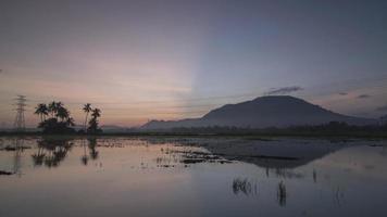Timelapse sunrise reflection of ray with coconut tree and hill video