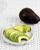 Sliced Avocado on Ceramic Plate. Copy Space photo