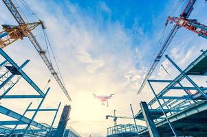 Drone over construction site. video surveillance or industrial inspection photo