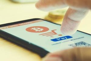 Man uses smart phone pay with bitcoin photo