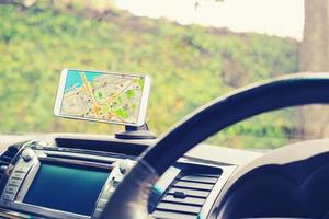 Female driver sitting in the car use mobile smart phone with map gps navigation application photo