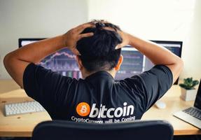 Despair man on down stock bitcoin graph market background. photo